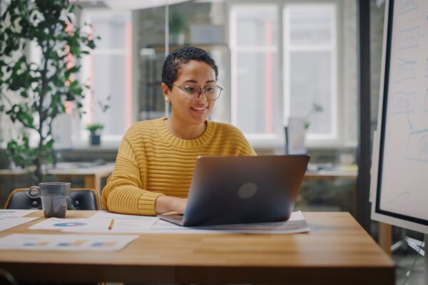 A young professional examines data on her laptop. Trayak's EcoImpact Sustainability Platform streamlines your data collection and reporting process.