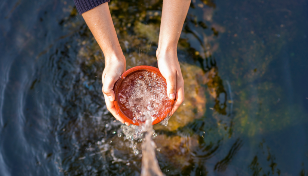 Water flows into a container held by a pair of hands